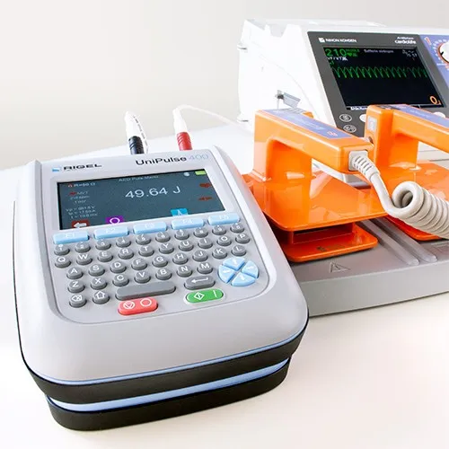 Sicherheitstechnische Kontrolle für AED 2 Defibrillatoren von Nihon Kohden mit Gerät für Sicherheitskontrolle und Display.